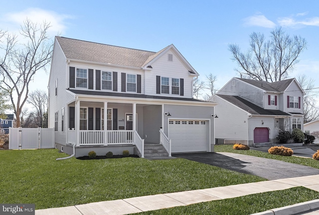 traditional-style home featuring an attached garage, aphalt driveway, a front yard, a gate, and covered porch