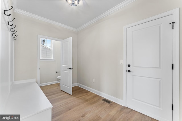 foyer featuring visible vents, ornamental molding, light wood finished floors, and baseboards
