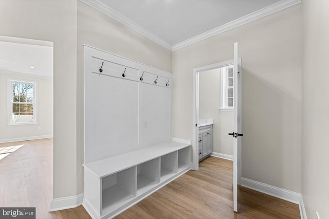 mudroom with baseboards, ornamental molding, and light wood-type flooring
