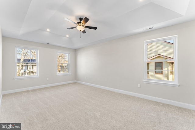 empty room featuring recessed lighting, a ceiling fan, a tray ceiling, and light carpet