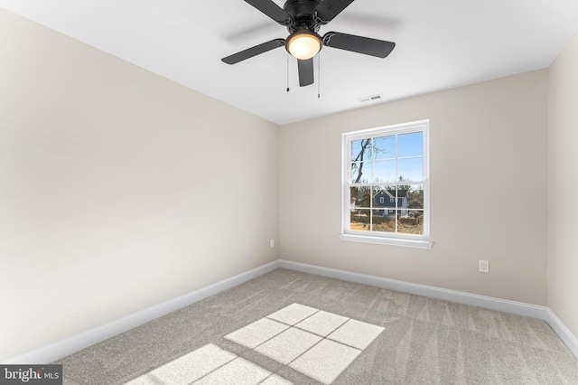 spare room with a ceiling fan, baseboards, visible vents, and light carpet