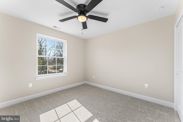 carpeted empty room featuring baseboards, a ceiling fan, and visible vents