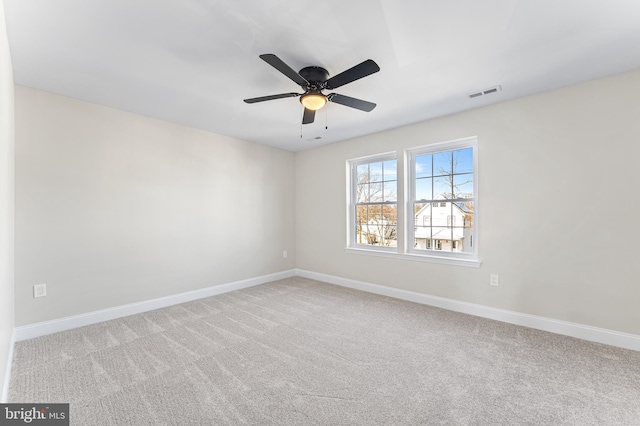 carpeted empty room featuring baseboards, a ceiling fan, and visible vents