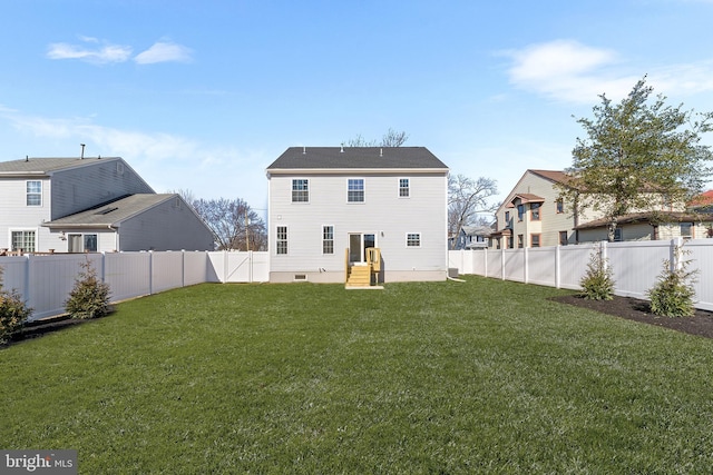 back of property with a lawn and a fenced backyard