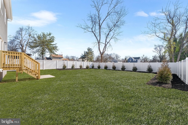 view of yard with stairs and a fenced backyard