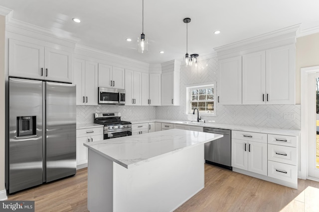 kitchen featuring a sink, decorative backsplash, stainless steel appliances, and white cabinetry