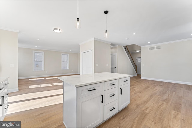 kitchen with crown molding, white cabinetry, open floor plan, and visible vents