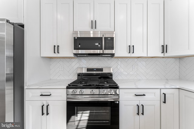 kitchen featuring light stone counters, decorative backsplash, white cabinetry, and stainless steel appliances