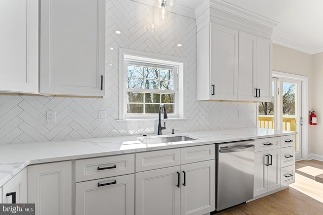 kitchen with white cabinetry, a sink, light stone counters, dishwasher, and light wood-style flooring
