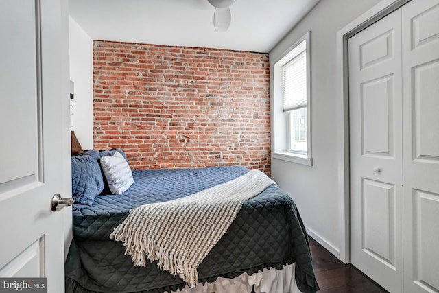 136 W Ostend St, Baltimore, MD 21230 - bedroom featuring brick wall, dark wood-type flooring, an accent wall, a ceiling fan, and baseboards