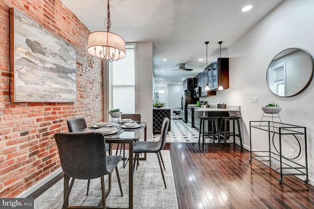 136 W Ostend St, Baltimore, MD 21230 - dining room with dark wood finished floors, baseboards, brick wall, a ceiling fan, and a chandelier