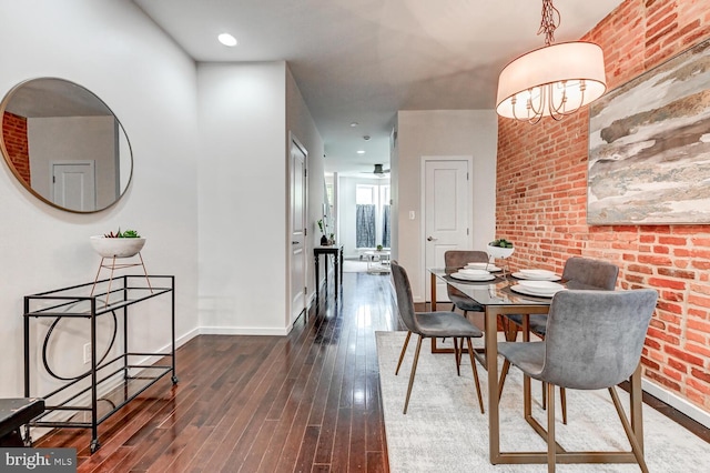136 W Ostend St, Baltimore, MD 21230 - dining area with brick wall, dark wood-type flooring, baseboards, and a chandelier