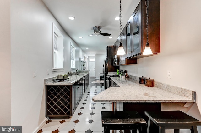 136 W Ostend St, Baltimore, MD 21230 - kitchen with a ceiling fan, light flooring, recessed lighting, a breakfast bar, and freestanding refrigerator