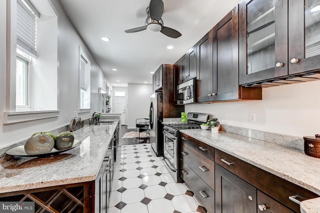 136 W Ostend St, Baltimore, MD 21230 - kitchen with appliances with stainless steel finishes, dark brown cabinets, ceiling fan, recessed lighting, and glass insert cabinets