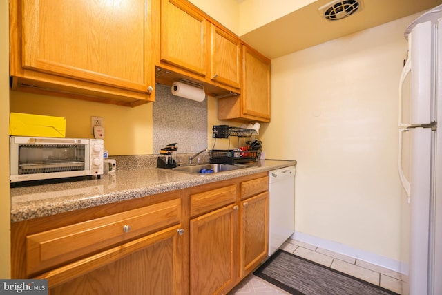 kitchen with visible vents, light tile patterned floors, a toaster, a sink, and white appliances