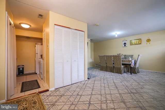 carpeted dining room featuring baseboards and visible vents