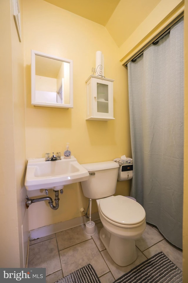 bathroom featuring tile patterned flooring, a sink, baseboards, and toilet