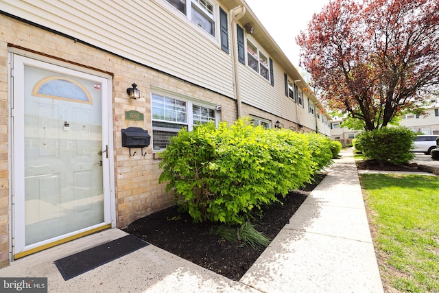 view of exterior entry with brick siding
