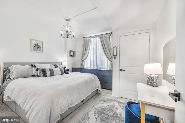 bedroom featuring a notable chandelier and light wood finished floors