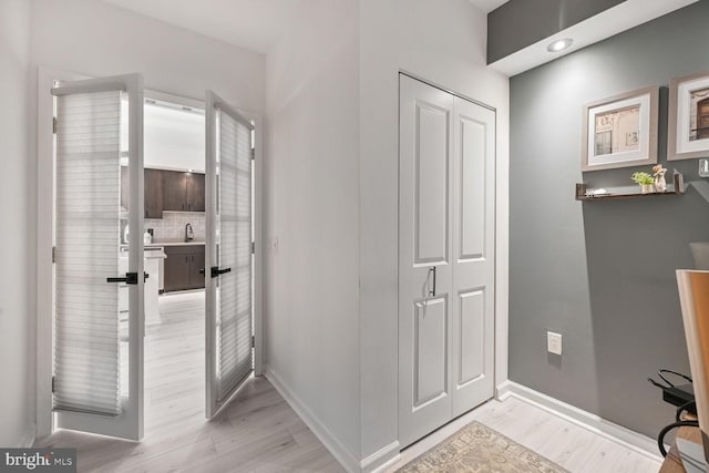 bathroom featuring baseboards, recessed lighting, backsplash, and wood finished floors