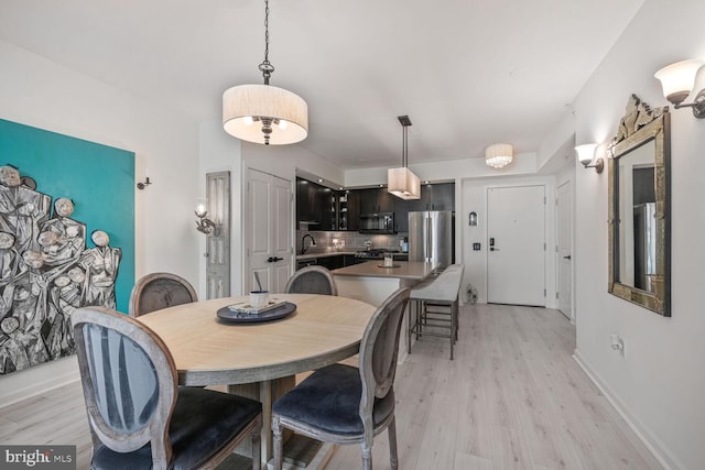 dining room featuring light wood-style floors and baseboards