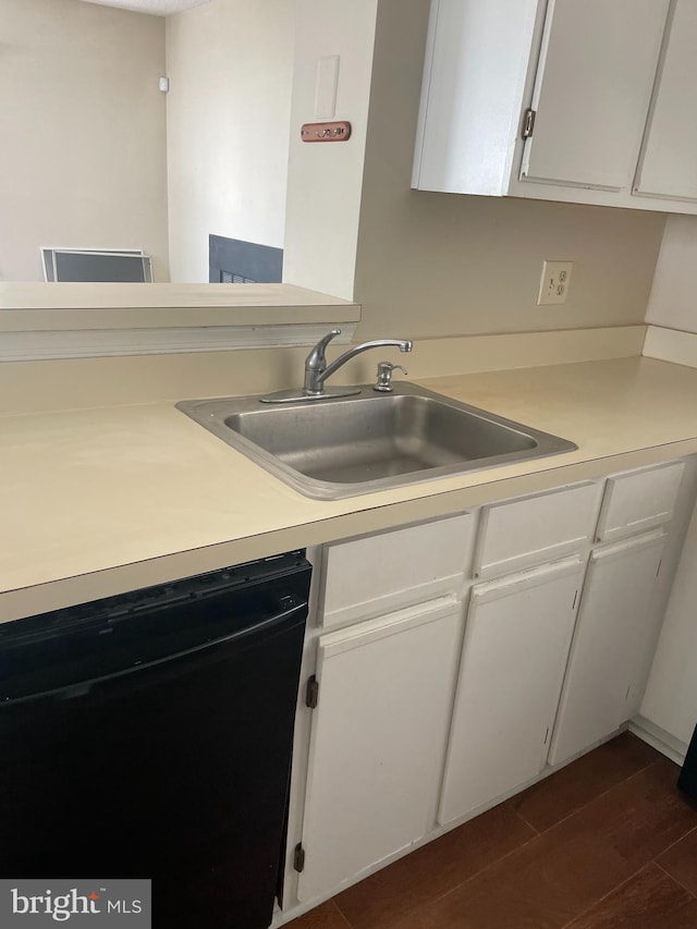 kitchen with black dishwasher, white cabinetry, a sink, and light countertops