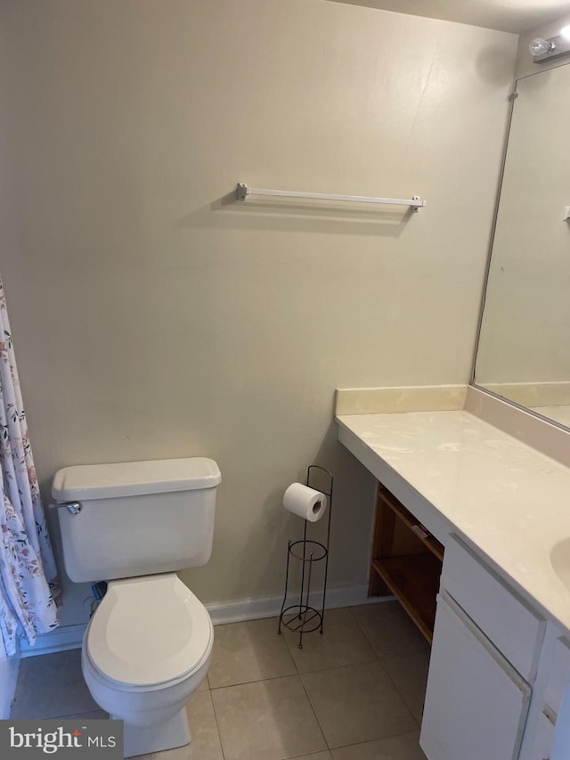 full bath featuring vanity, baseboards, tile patterned floors, and toilet