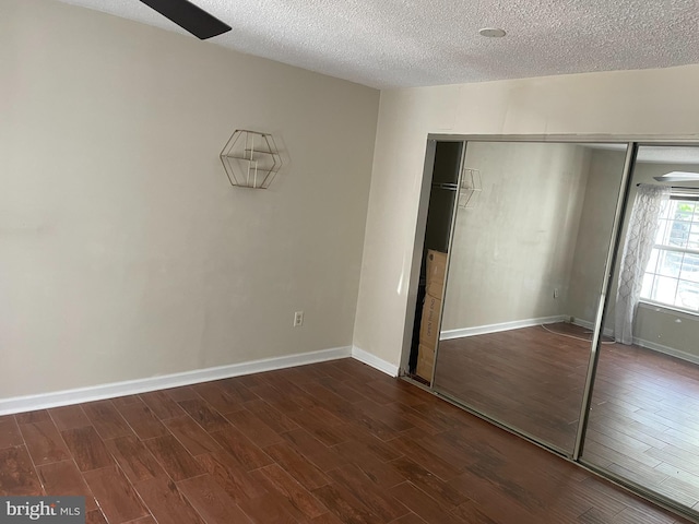 unfurnished bedroom featuring a textured ceiling, wood finished floors, and a closet