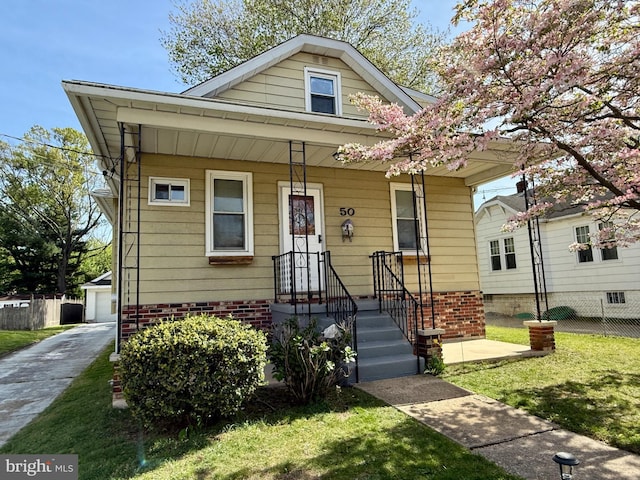 bungalow featuring fence and a front lawn