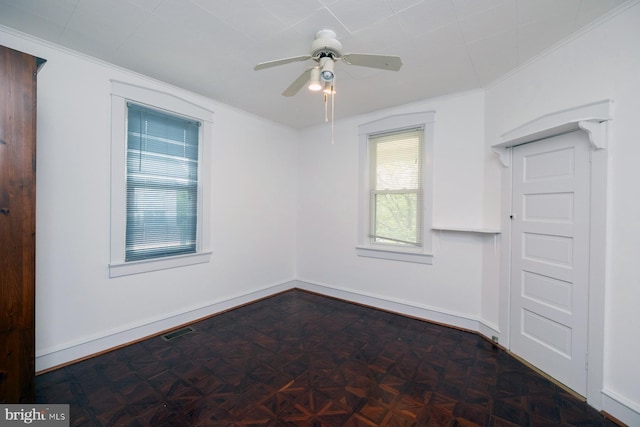 unfurnished room featuring ceiling fan, visible vents, baseboards, and ornamental molding