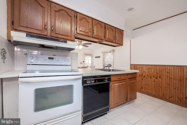 kitchen with a sink, black dishwasher, under cabinet range hood, light countertops, and white electric stove