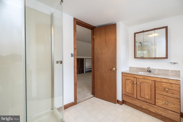 full bathroom with vanity, baseboards, a shower stall, and tile patterned floors