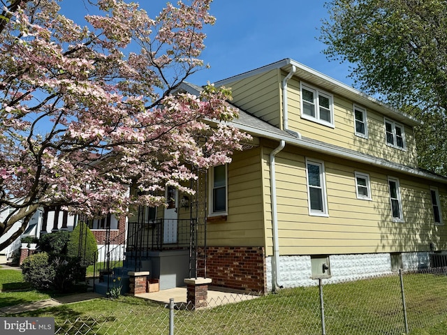 view of property exterior with a yard and fence