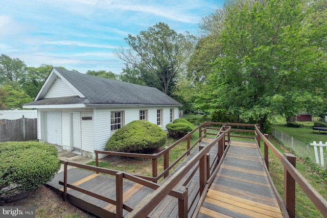 exterior space featuring an outbuilding, fence, and a detached garage