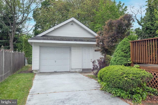 detached garage with fence and driveway