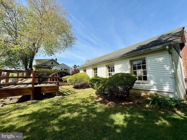view of home's exterior featuring a yard and a deck