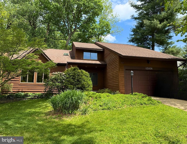 view of front of home featuring a garage, a front yard, and driveway