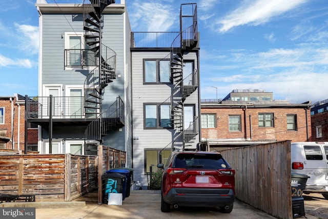 view of property featuring stairs and fence