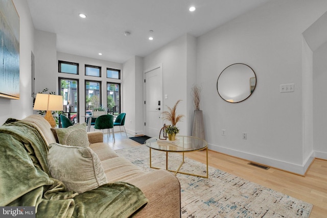living area featuring recessed lighting, baseboards, visible vents, and wood finished floors