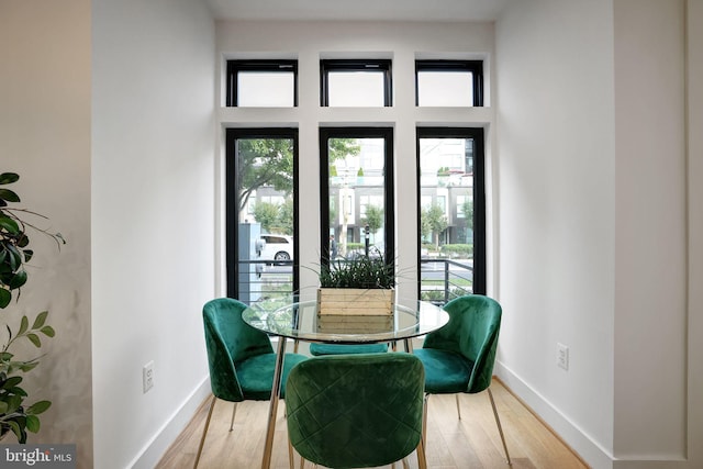 dining space with baseboards and wood finished floors