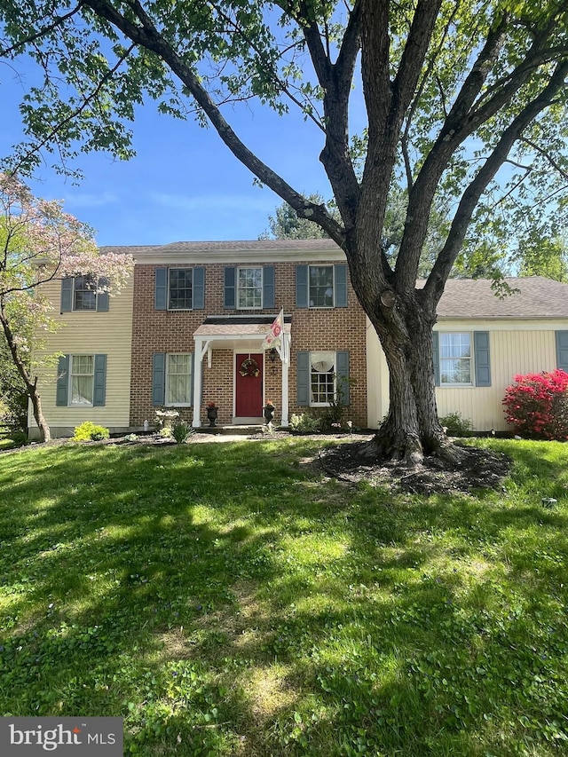 view of front of house featuring brick siding and a front yard