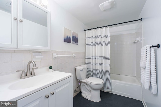 full bath featuring vanity, toilet, tile patterned floors, shower / bath combo with shower curtain, and tile walls