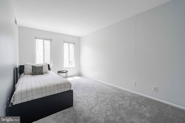 carpeted bedroom featuring baseboards and visible vents