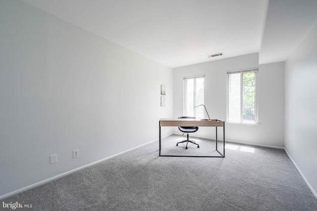 unfurnished office featuring visible vents, carpet, and baseboards