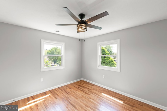 unfurnished room featuring baseboards, a wealth of natural light, and light wood-type flooring
