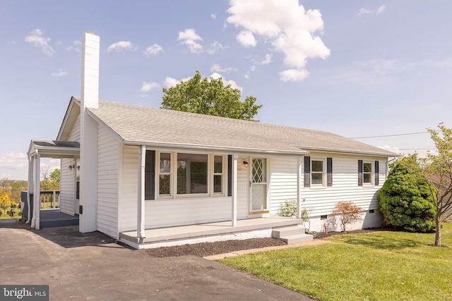 view of front of property with covered porch, a shingled roof, a chimney, and a front lawn