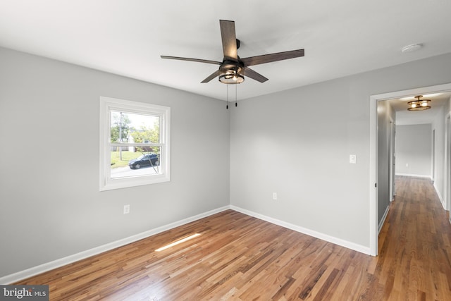 spare room featuring baseboards, a ceiling fan, and wood finished floors