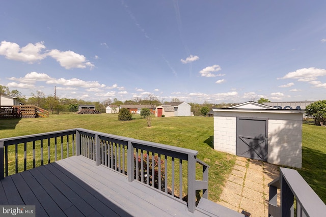 wooden deck with a storage shed, an outbuilding, and a lawn