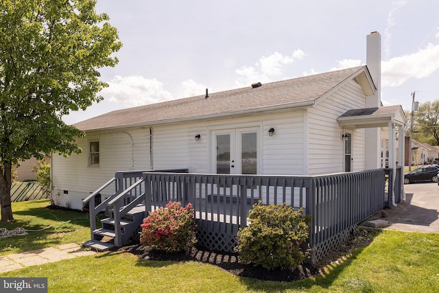 rear view of house featuring french doors, a wooden deck, and a yard