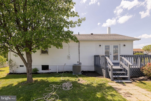 rear view of house featuring a deck, central AC unit, a chimney, french doors, and a lawn